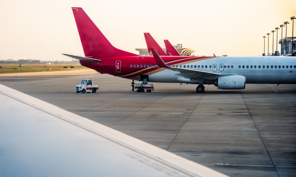 Cola de avión y carro guardando maletas